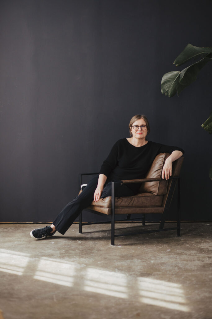Ein Porträt der Schriftstellerin Silke Knäpper, leger sitzend auf einem Ledersessel